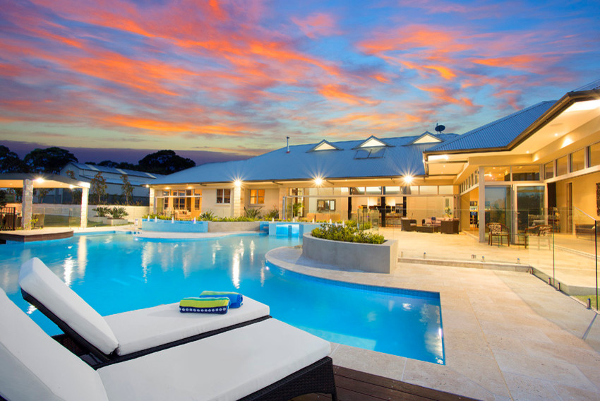 Photo of a large country backyard custom-shaped infinity pool in Sydney with a water feature and natural stone pavers.