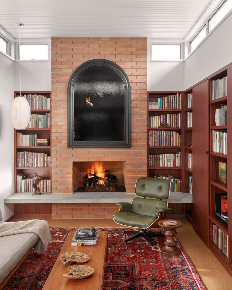 Inspiration for a mid-sized midcentury open concept family room in Austin with a library, white walls, cork floors, a standard fireplace, a brick fireplace surround, no tv, brown floor and timber.