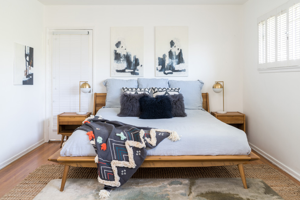 Imagen de dormitorio retro grande sin chimenea con paredes blancas y suelo de madera en tonos medios