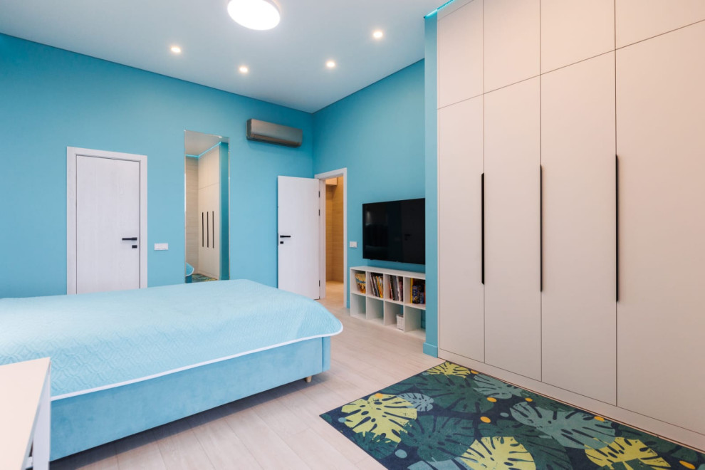 Cette image montre une chambre d'enfant de 4 à 10 ans avec un mur bleu et un sol en vinyl.