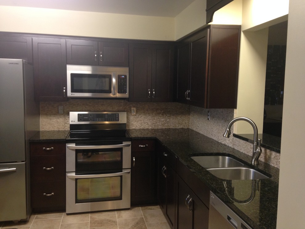 Inspiration for a mid-sized transitional l-shaped porcelain tile enclosed kitchen remodel with an undermount sink, shaker cabinets, dark wood cabinets, granite countertops, beige backsplash, stone tile backsplash, stainless steel appliances and an island