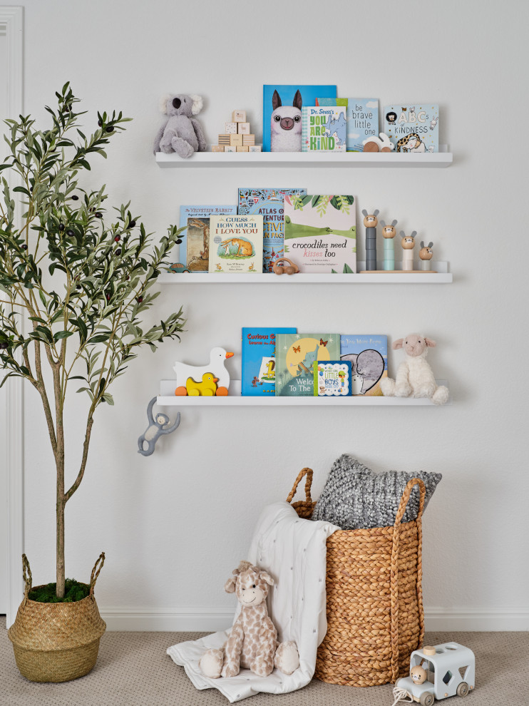 Belterra Project- Furnishings, Light Fixtures & Interior Design - In this the sweet nursery, the designer specified a blue gray paneled wall as the focal point behind the white and acrylic crib.  A comfortable cotton and linen glider and ottoman provide the perfect spot to rock baby to sleep.  A dresser with a changing table topper provides additional function, while adorable car artwork, a woven mirror, and a sheepskin rug add finishing touches and additional texture.