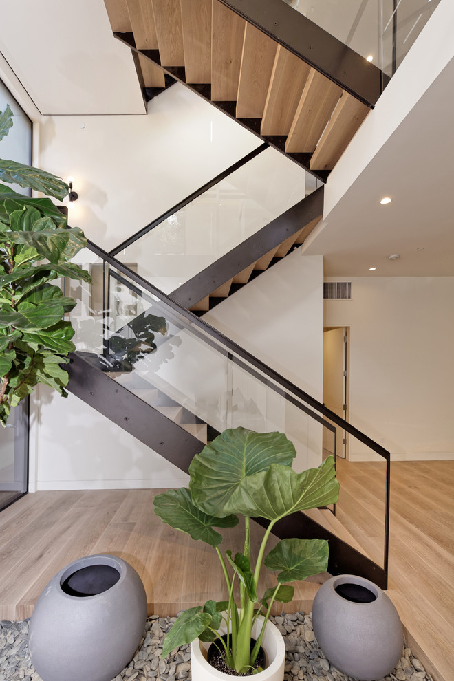 Inspiration for a large contemporary wood u-shaped staircase in San Francisco with open risers and glass railing.