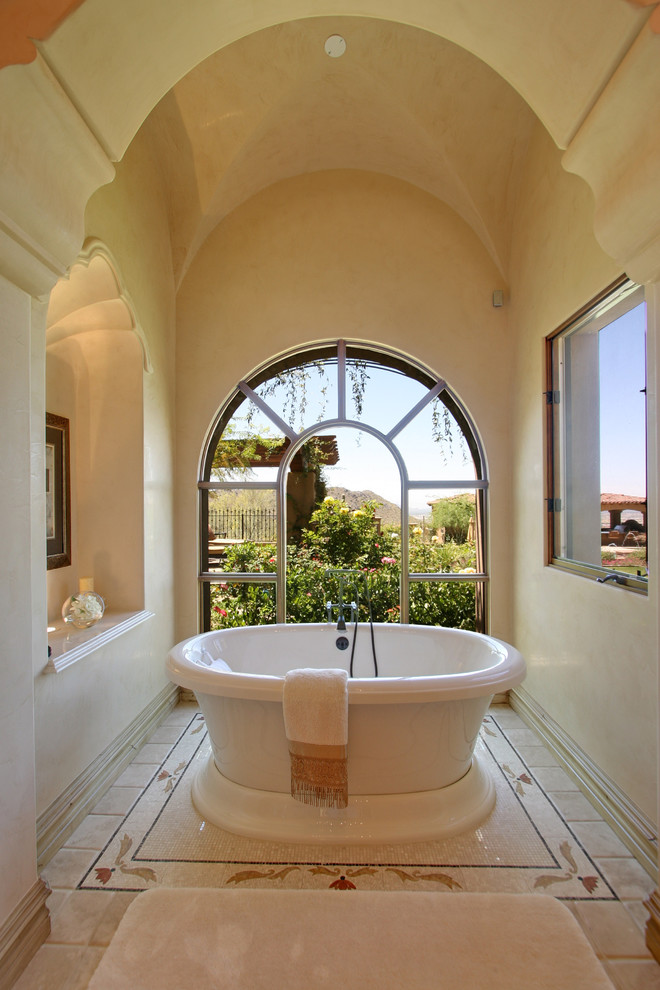 Inspiration for an expansive mediterranean master bathroom in Phoenix with flat-panel cabinets, light wood cabinets, a hot tub, a double shower, a one-piece toilet, beige tile, stone tile, beige walls, travertine floors, an integrated sink and tile benchtops.