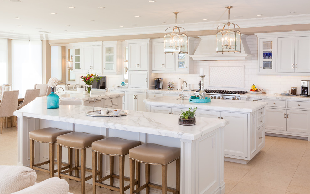 Photo of a beach style kitchen in Orange County with white cabinets and multiple islands.