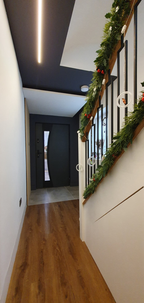 Foto di una porta d'ingresso contemporanea di medie dimensioni con pareti bianche, pavimento in gres porcellanato, una porta singola, una porta in metallo, pavimento grigio, soffitto ribassato e pareti in legno
