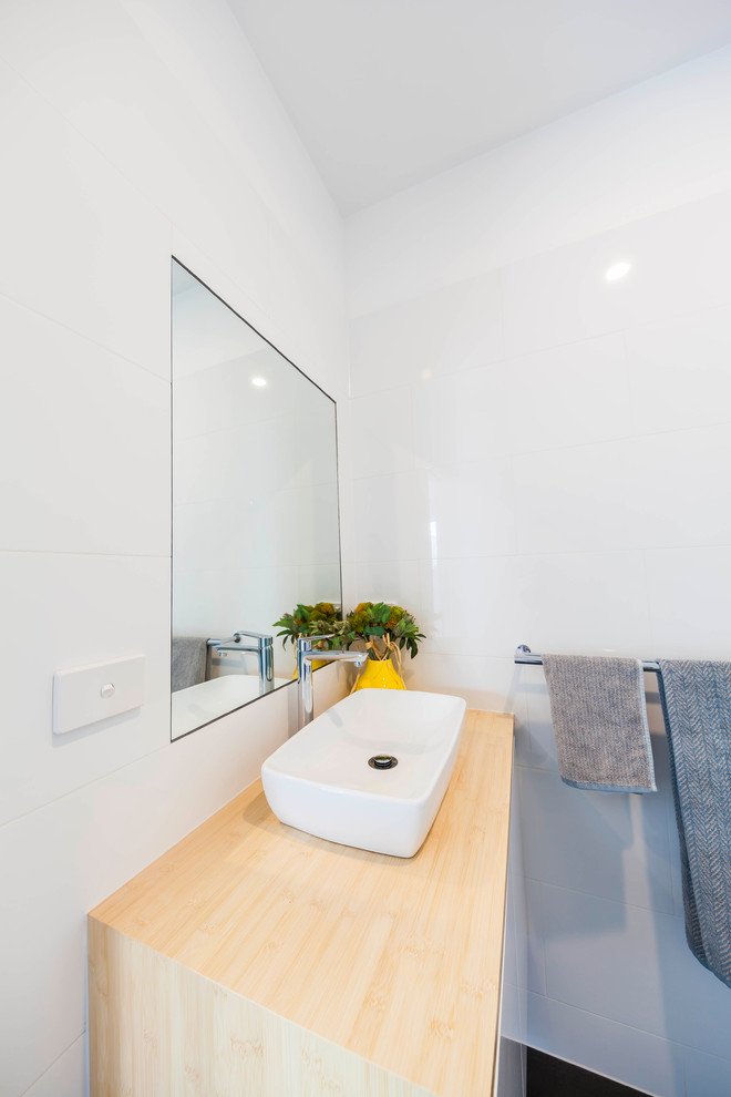 Small transitional 3/4 bathroom in Melbourne with white cabinets, white tile, ceramic tile, white walls, ceramic floors and wood benchtops.