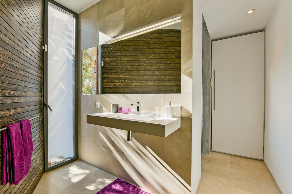 This is an example of a mid-sized contemporary powder room in Malaga with beige walls and a wall-mount sink.