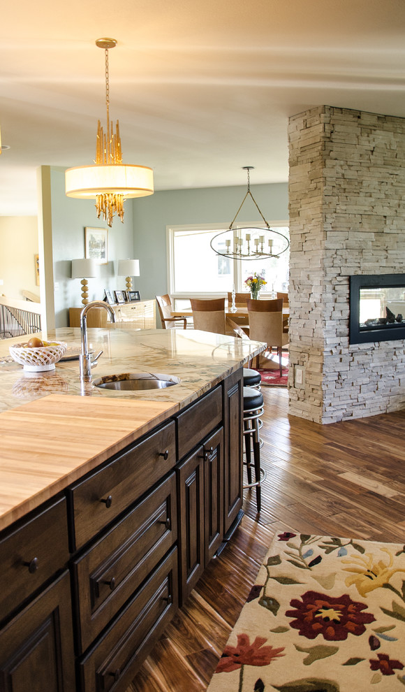 Eat-in kitchen - large transitional single-wall medium tone wood floor eat-in kitchen idea in Denver with a single-bowl sink, dark wood cabinets, quartzite countertops, an island, stainless steel appliances and raised-panel cabinets