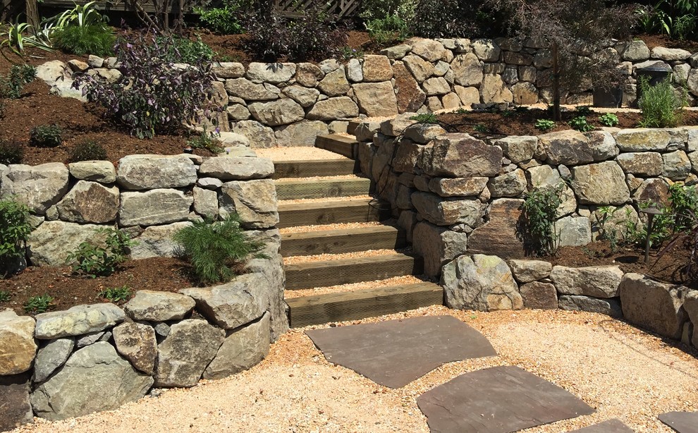 Photo of a large traditional sloped full sun formal garden for spring in San Francisco with a fire feature and concrete pavers.