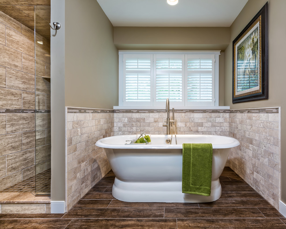 Inspiration for a mid-sized transitional master bathroom in Detroit with a freestanding tub, an alcove shower, beige tile, an undermount sink, travertine, shaker cabinets, white cabinets, a one-piece toilet, beige walls, dark hardwood floors, granite benchtops, brown floor and a hinged shower door.