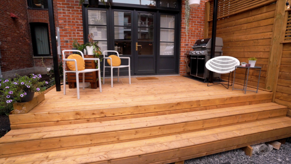 Diseño de terraza planta baja de estilo americano pequeña en patio trasero con privacidad