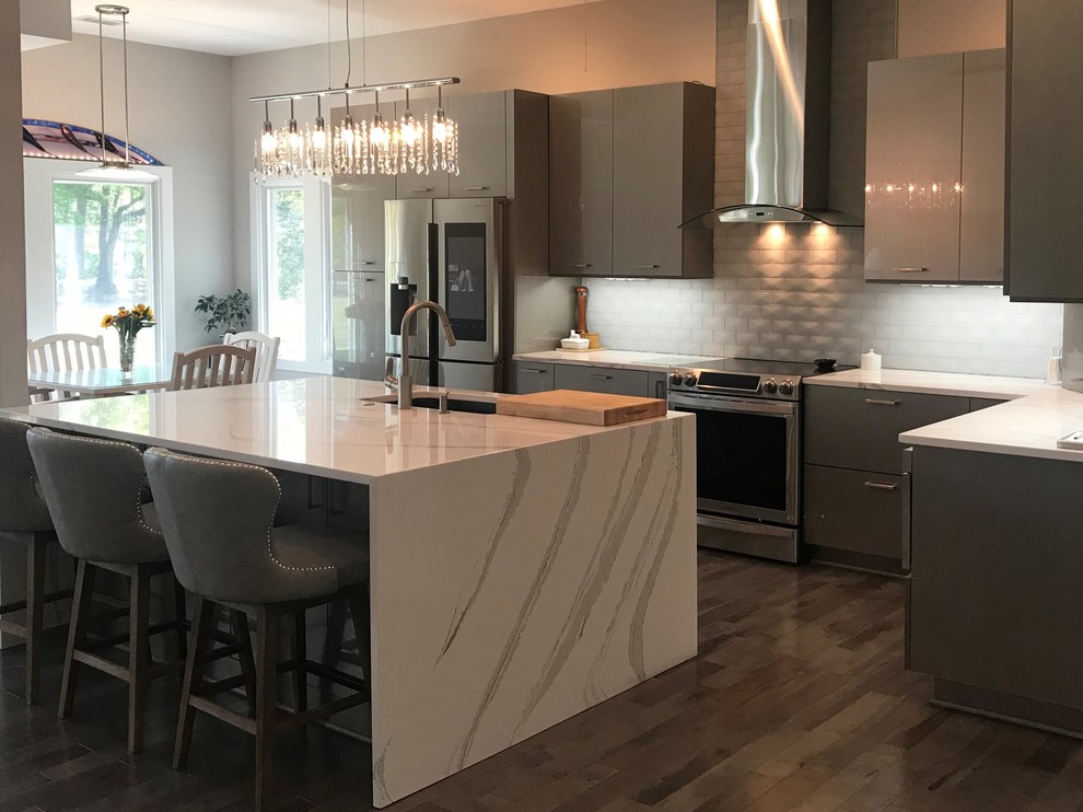 Photo of a transitional u-shaped kitchen in Raleigh with an integrated sink, flat-panel cabinets, grey cabinets, marble benchtops, brown floor and white benchtop.