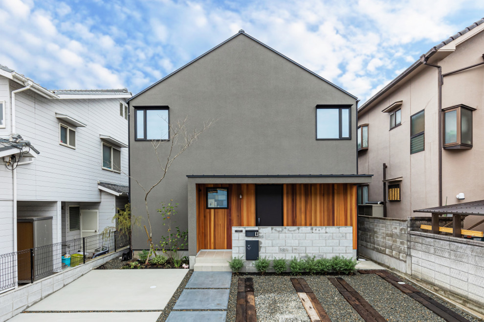 Ejemplo de fachada de casa gris y negra moderna de tamaño medio de dos plantas con tejado a dos aguas y tejado de metal