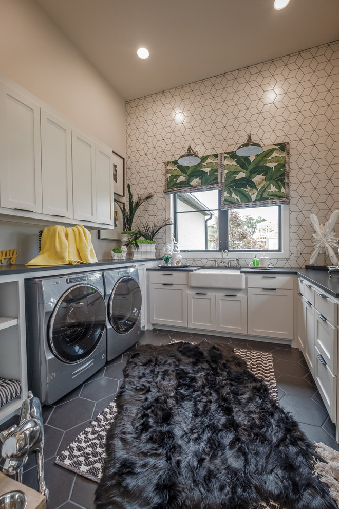 Photo of a mid-sized eclectic u-shaped dedicated laundry room in Dallas with shaker cabinets, white cabinets, a farmhouse sink, soapstone benchtops, multi-coloured walls, porcelain floors, a side-by-side washer and dryer, grey floor and grey benchtop.