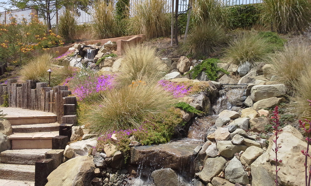 Inspiration for a large traditional sloped full sun garden in Los Angeles with with waterfall and gravel.