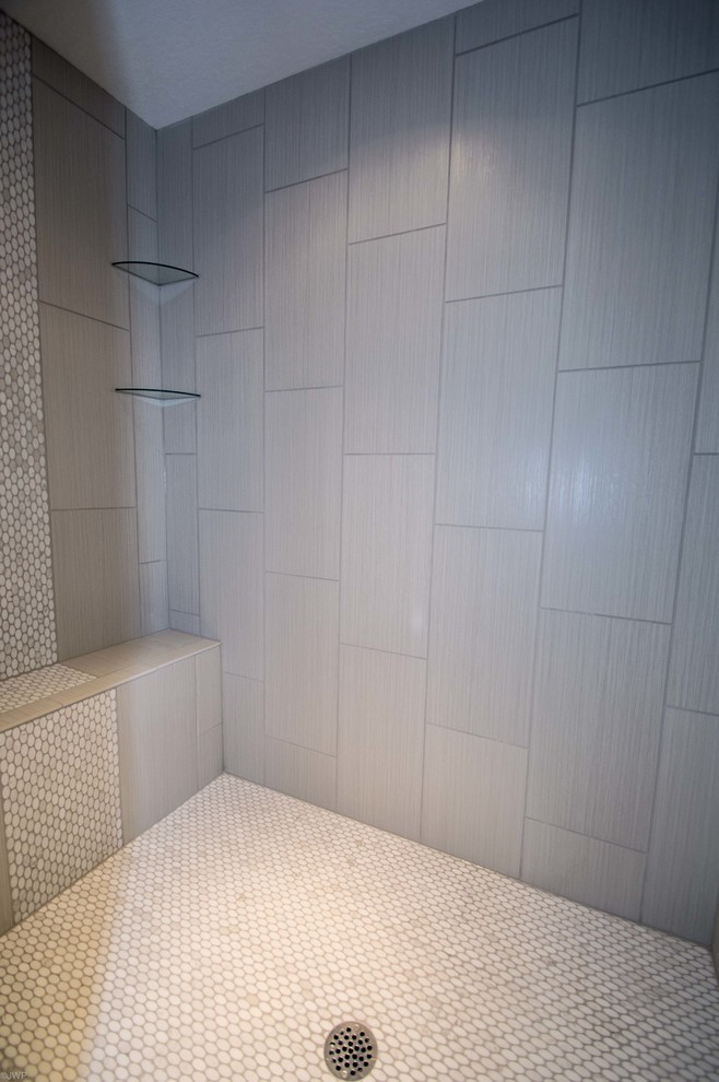Mid-sized transitional 3/4 gray tile and porcelain tile porcelain tile and black floor drop-in bathtub photo in Chicago with shaker cabinets, gray cabinets, gray walls, an undermount sink, solid surface countertops and a hinged shower door