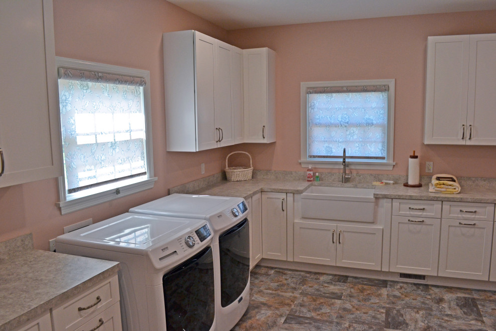 Large traditional l-shaped separated utility room in Other with a belfast sink, shaker cabinets, white cabinets, laminate countertops, pink walls, ceramic flooring, a side by side washer and dryer, multi-coloured floors and pink worktops.
