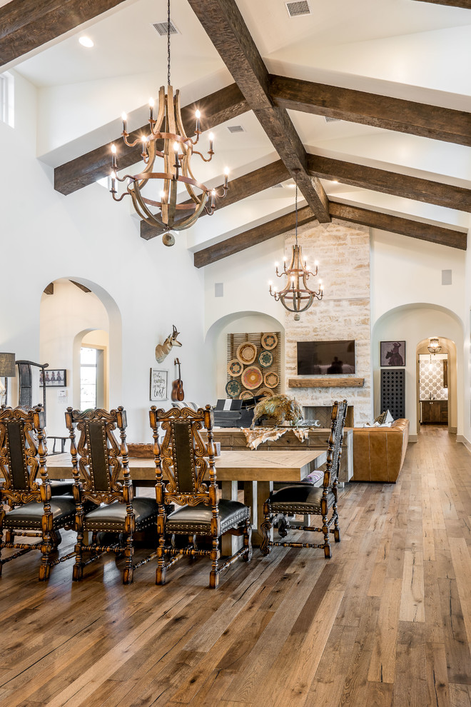 Photo of a mediterranean open plan dining in Austin with white walls, medium hardwood floors and brown floor.