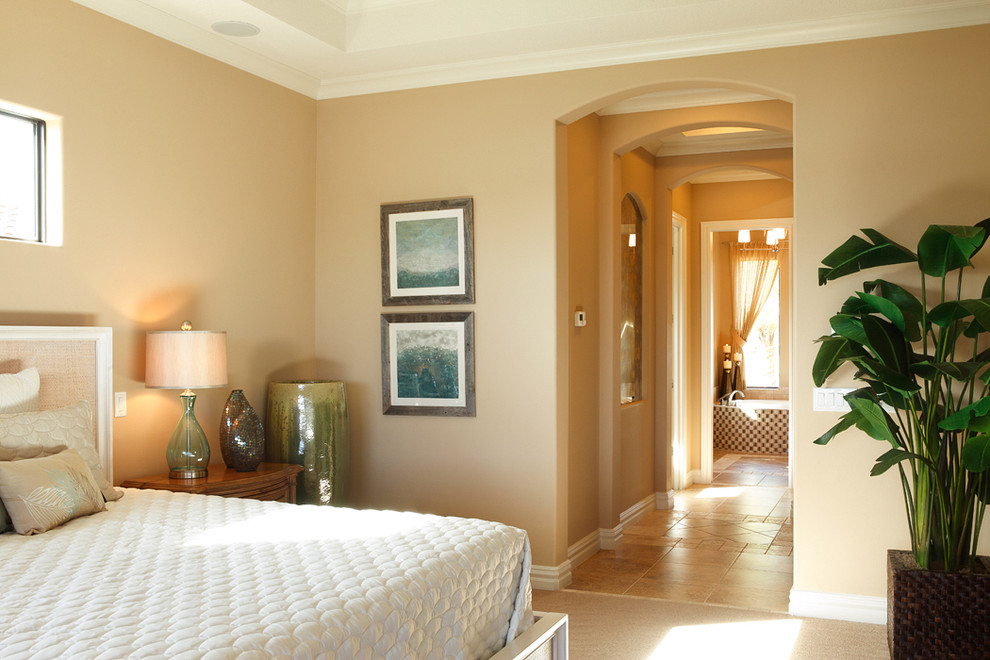 Inspiration for a mid-sized tropical master bedroom in Orlando with beige walls, carpet and beige floor.