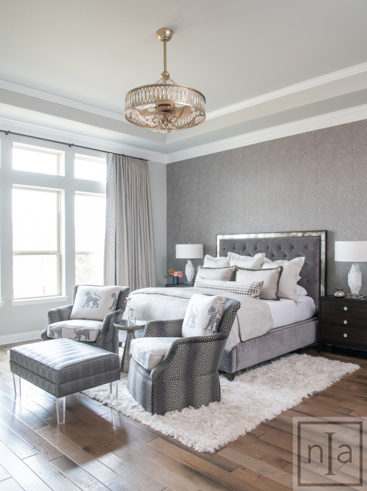 This is an example of a transitional master bedroom in Dallas with grey walls, medium hardwood floors, no fireplace, brown floor and wallpaper.