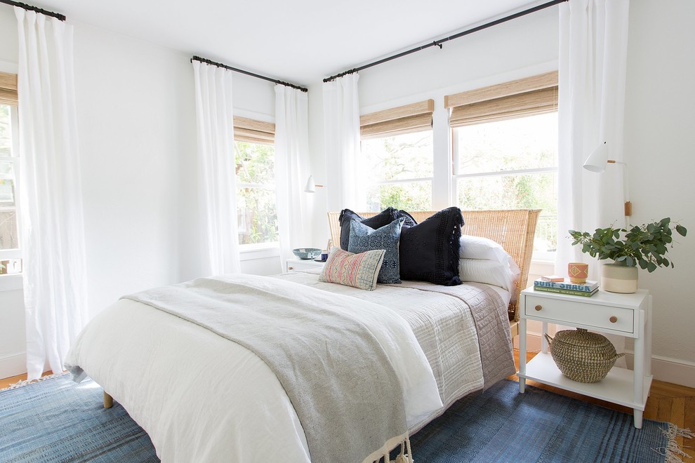 Bedroom - coastal medium tone wood floor bedroom idea in Sacramento with white walls