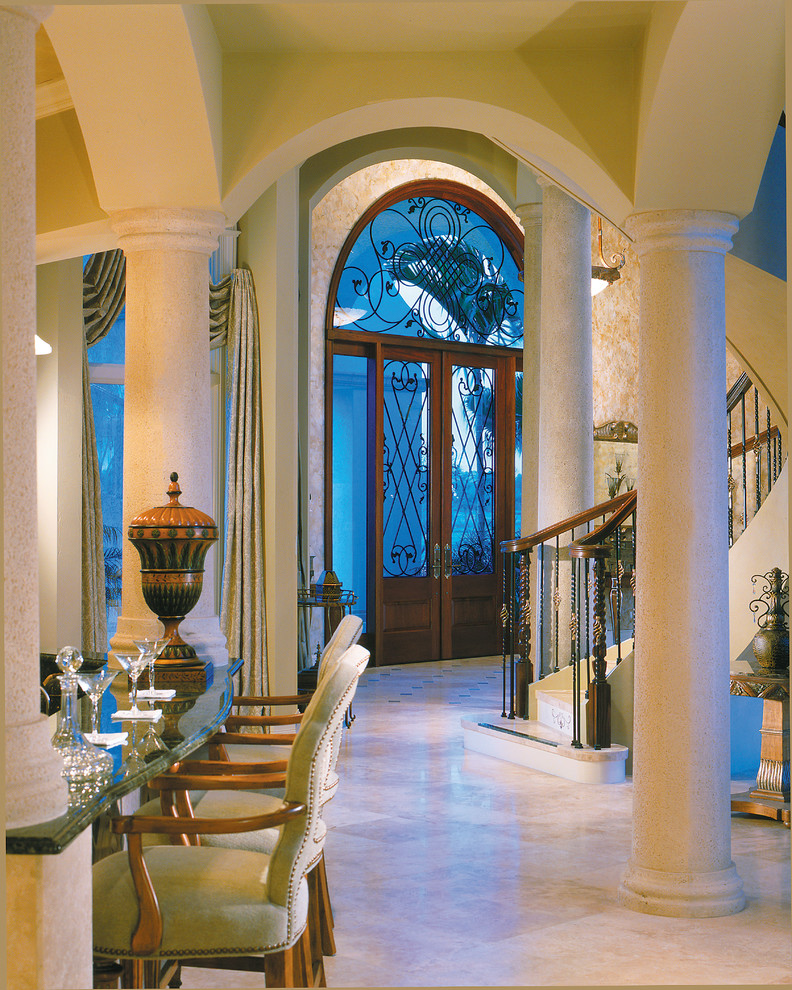 Photo of a large mediterranean foyer in Miami with beige walls, travertine floors, a double front door and a dark wood front door.