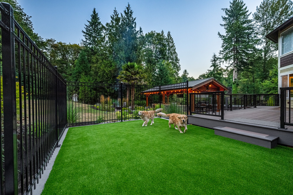 This is an example of a large traditional back patio in Seattle with an outdoor kitchen, natural stone paving and a pergola.