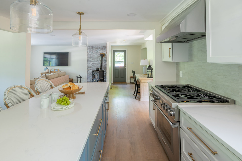 Eat-in kitchen - mid-sized transitional l-shaped light wood floor and brown floor eat-in kitchen idea in Boston with an undermount sink, shaker cabinets, white cabinets, quartz countertops, gray backsplash, ceramic backsplash, stainless steel appliances, an island and white countertops