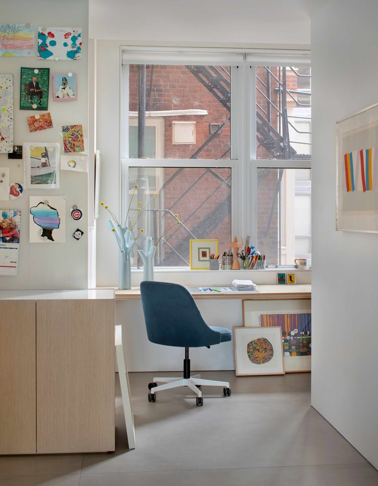 Photo of a mid-sized modern craft room in Denver with white walls, no fireplace, light hardwood floors, a built-in desk and beige floor.
