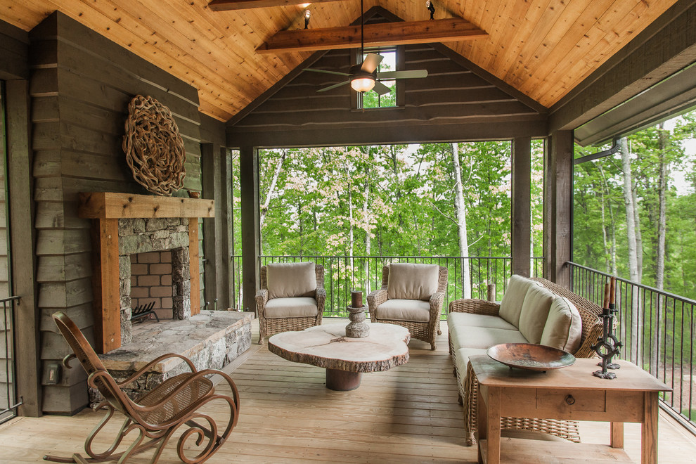 Deck - rustic deck idea with a roof extension and a fireplace