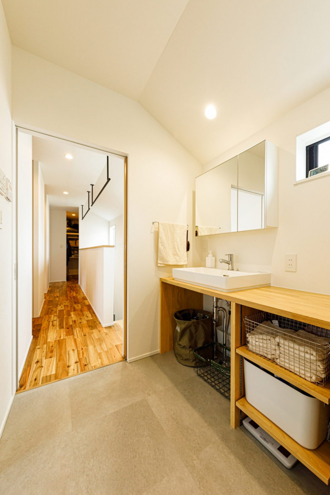 Photo of a mid-sized industrial powder room in Tokyo Suburbs with light wood cabinets, white tile, wood benchtops, beige benchtops, a built-in vanity, wallpaper and wallpaper.