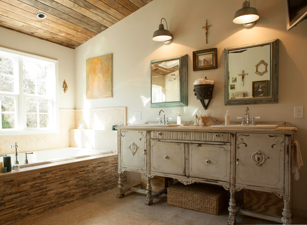 Design ideas for a traditional master bathroom in Charlotte with a drop-in sink, furniture-like cabinets, distressed cabinets, wood benchtops, a drop-in tub, a double shower, multi-coloured tile, stone tile, beige walls and ceramic floors.