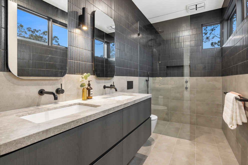 Idéer för mellanstora funkis grått en-suite badrum, med skåp i mörkt trä, en öppen dusch, en vägghängd toalettstol, grå kakel, porslinskakel, klinkergolv i porslin, ett undermonterad handfat, marmorbänkskiva, grått golv och med dusch som är öppen