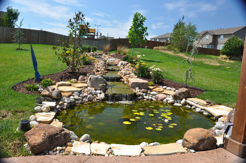 Photo of a traditional backyard garden in Kansas City with a water feature.
