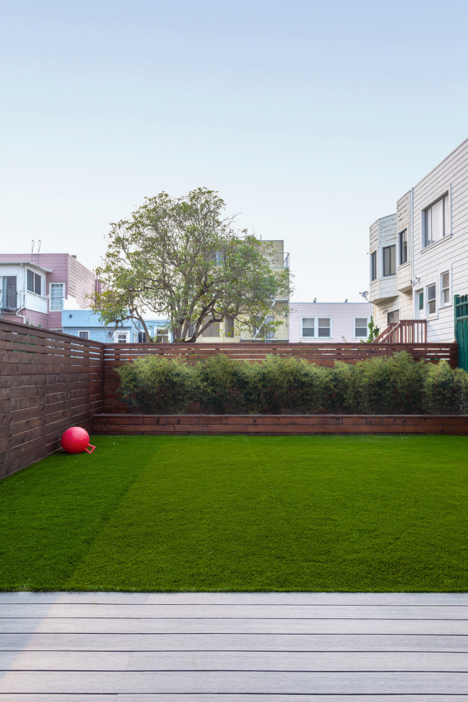 Imagen de jardín moderno de tamaño medio en patio trasero con privacidad y con madera