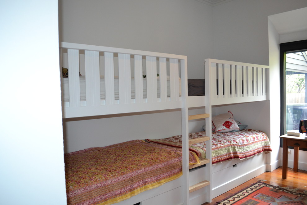 Photo of a mid-sized eclectic guest bedroom in Geelong with white walls and medium hardwood floors.