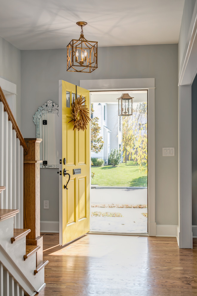 Inspiration for a mid-sized arts and crafts foyer in Orange County with grey walls, a single front door, a yellow front door and medium hardwood floors.