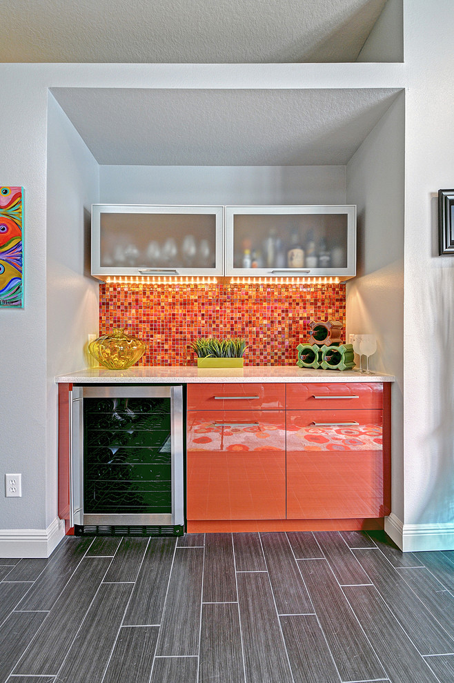 Photo of a mid-sized contemporary single-wall home bar in Tampa with flat-panel cabinets, orange cabinets, multi-coloured splashback, mosaic tile splashback and grey floor.