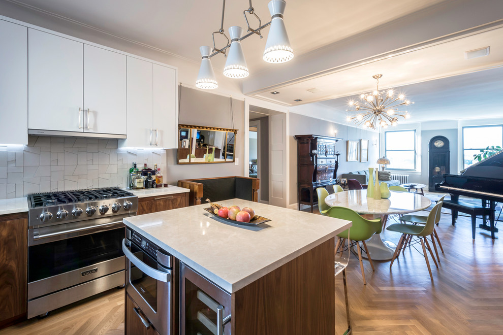 This is an example of a mid-sized contemporary u-shaped separate kitchen in New York with an undermount sink, flat-panel cabinets, dark wood cabinets, quartzite benchtops, beige splashback, ceramic splashback, stainless steel appliances, light hardwood floors and with island.
