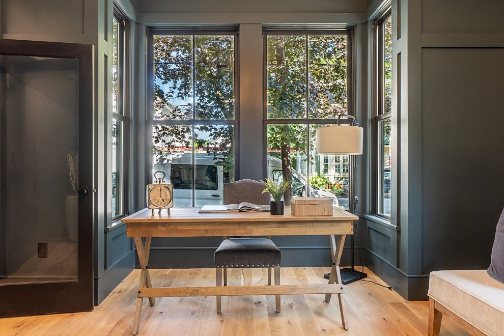 Imagen de despacho de estilo de casa de campo grande con paredes azules, suelo de madera clara, escritorio independiente, suelo beige y machihembrado