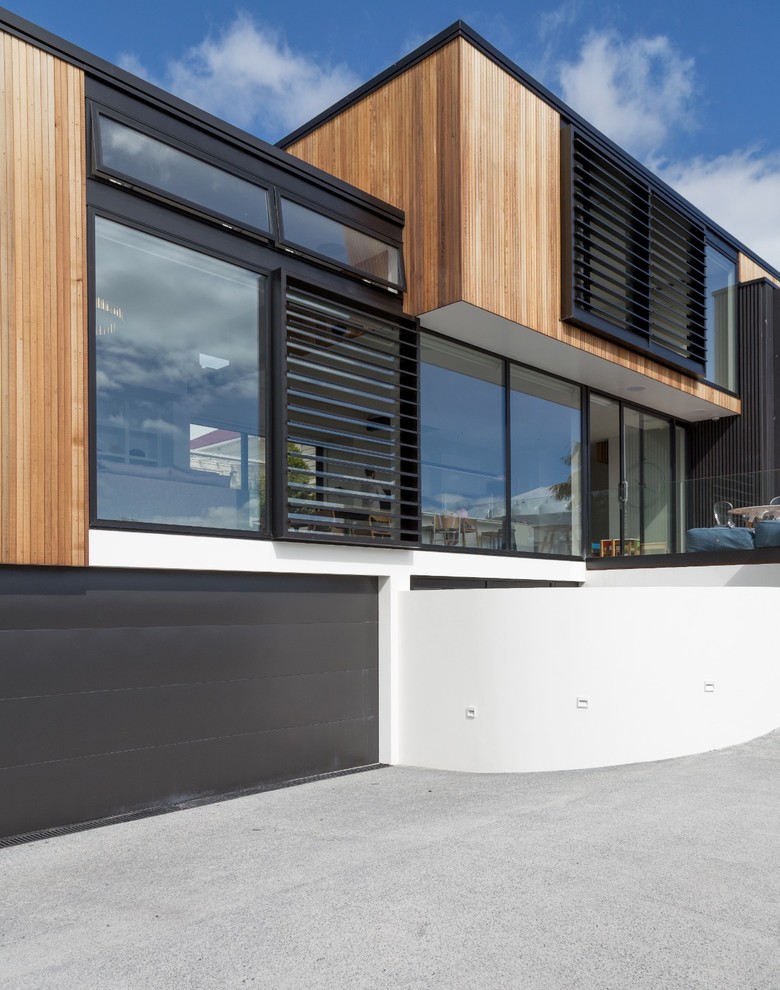 Inspiration for a large contemporary three-storey black exterior in Auckland with wood siding and a flat roof.