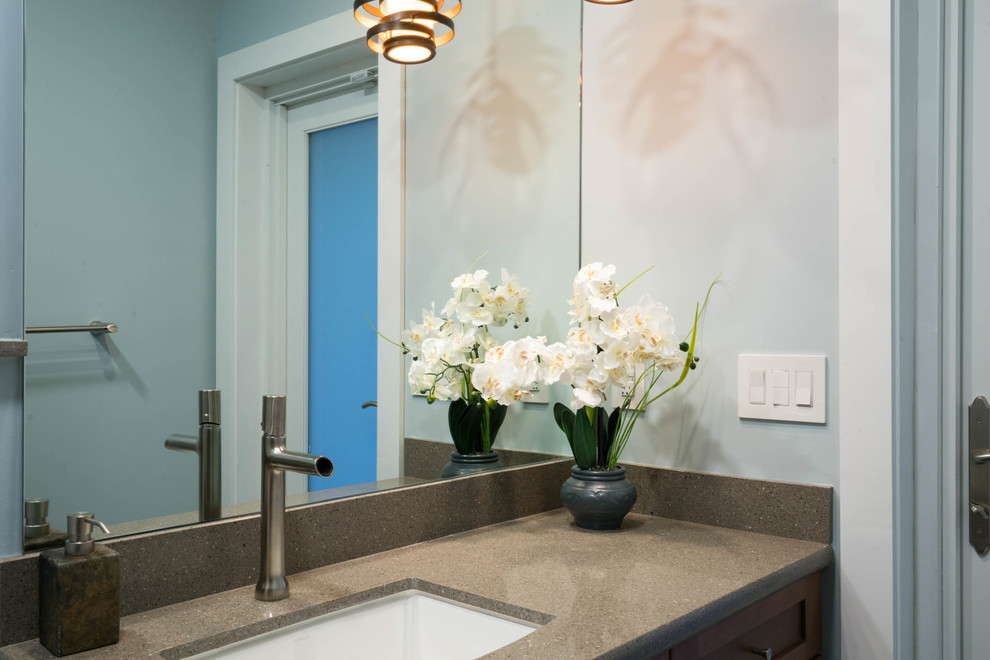 Inspiration for a small transitional bathroom in Jacksonville with recessed-panel cabinets, medium wood cabinets, an open shower, a two-piece toilet, black tile, porcelain tile, blue walls, porcelain floors, an undermount sink and engineered quartz benchtops.