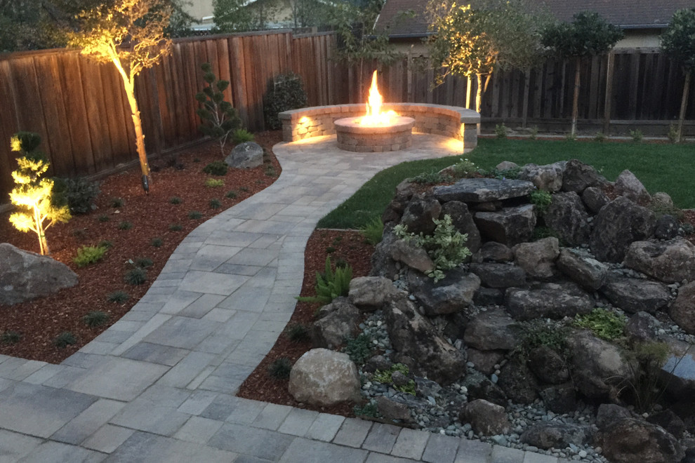 Design ideas for an expansive transitional backyard patio in San Francisco with a fire feature, natural stone pavers and no cover.