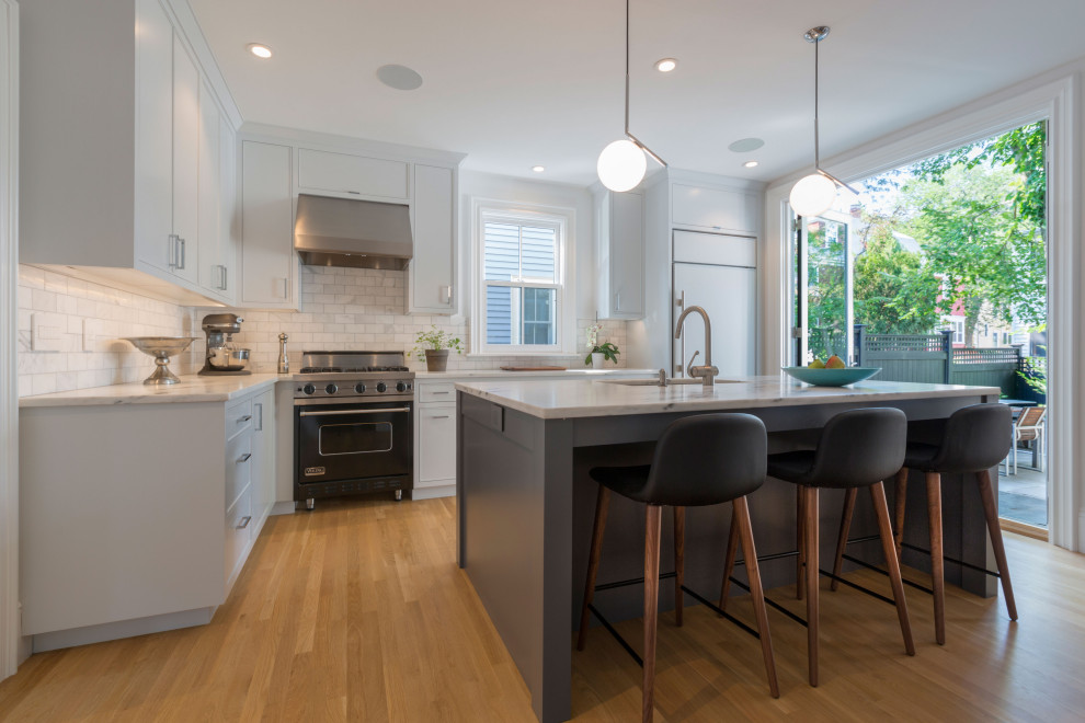 Example of a large transitional l-shaped medium tone wood floor kitchen pantry design in Boston with a single-bowl sink, beaded inset cabinets, white cabinets, marble countertops, gray backsplash, marble backsplash, stainless steel appliances, an island and white countertops