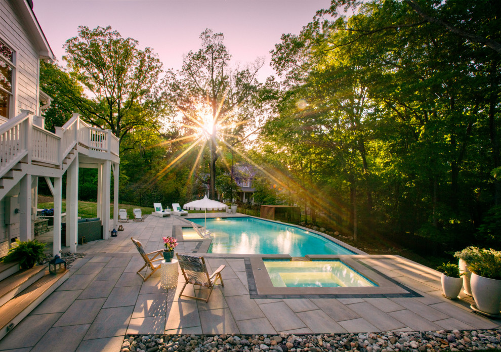 Photo of a modern backyard custom-shaped natural pool in Raleigh with with a pool and concrete pavers.