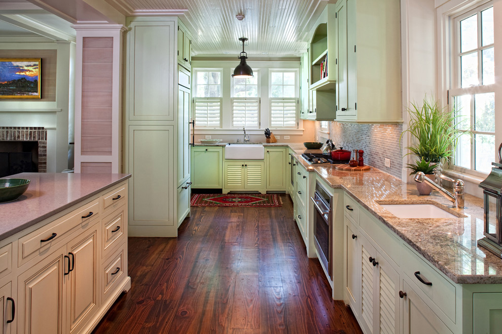 Design ideas for a traditional u-shaped kitchen in Atlanta with an undermount sink, shaker cabinets, green cabinets, grey splashback, glass tile splashback, panelled appliances, medium hardwood floors and with island.