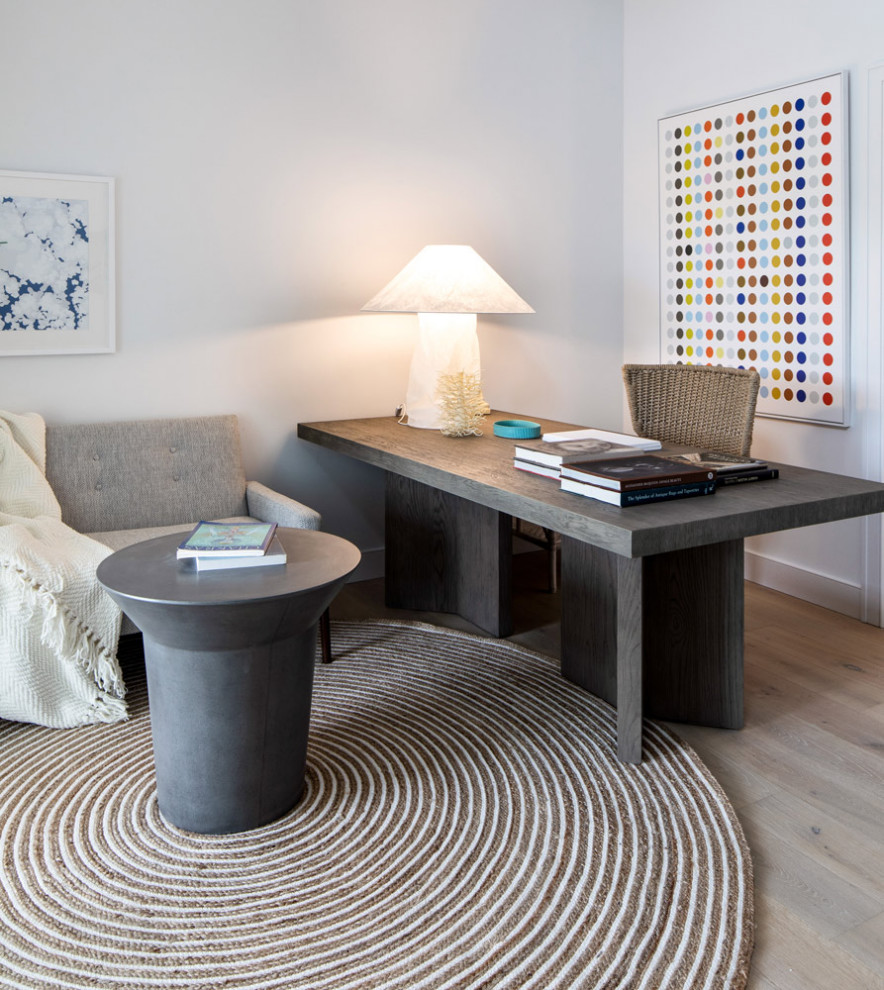 Ejemplo de estudio minimalista de tamaño medio sin chimenea con paredes blancas, suelo de madera en tonos medios y escritorio empotrado