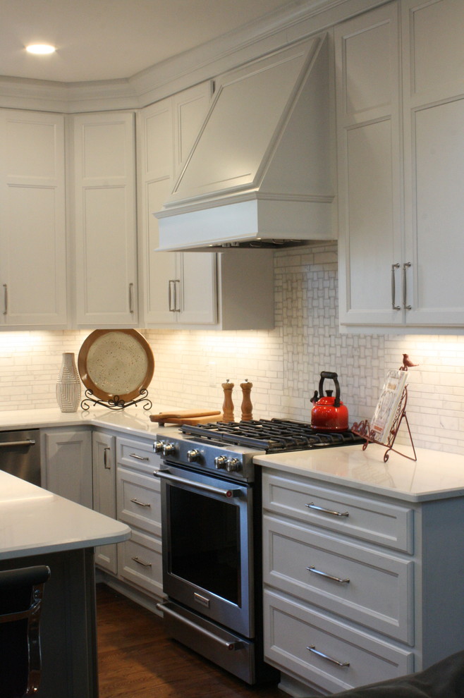 Kitchen - transitional dark wood floor and brown floor kitchen idea in Nashville with a farmhouse sink, flat-panel cabinets, white cabinets, white backsplash, stainless steel appliances, an island and white countertops