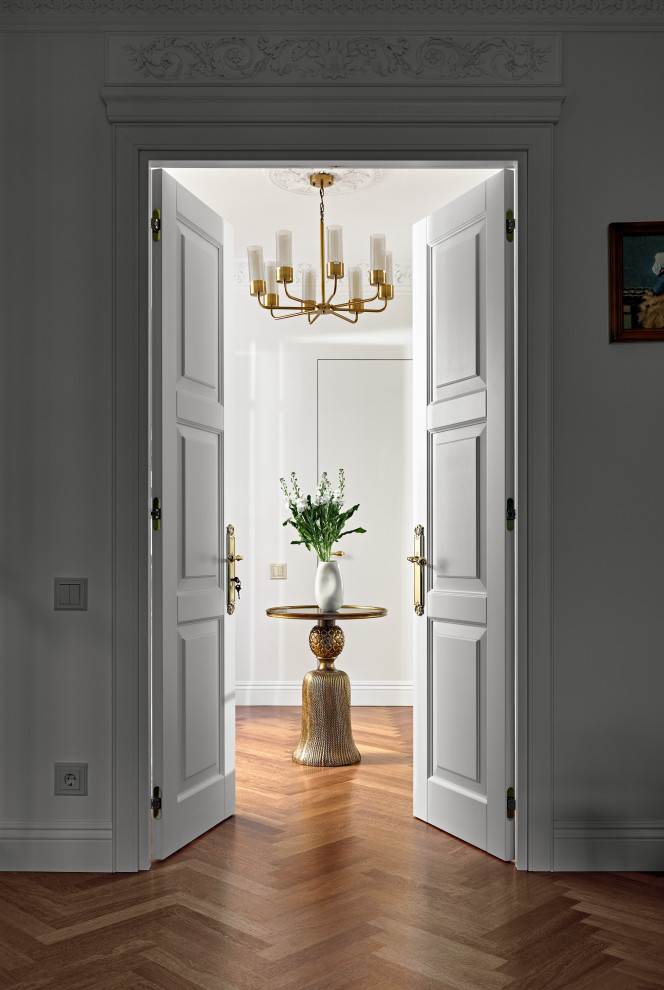 Ejemplo de puerta principal clásica renovada grande con paredes blancas, suelo de madera en tonos medios, puerta simple, puerta metalizada y suelo marrón